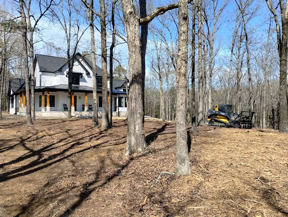Cleared land beside a house with mulching machine